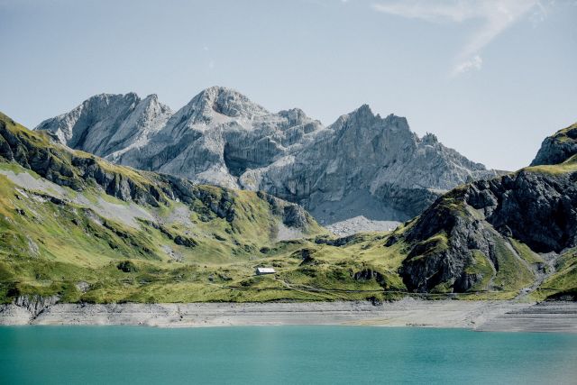Ein Bild der Alpen mit einem See im Vordergrund