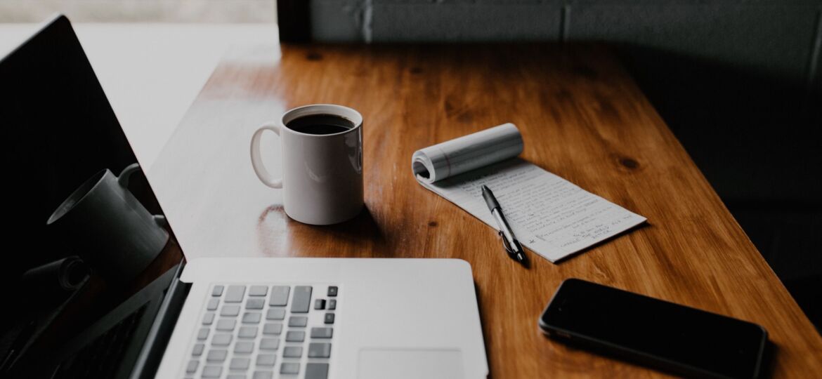 Die Vorbereitung eines Interviews mit Notebook, Zettel und Stift