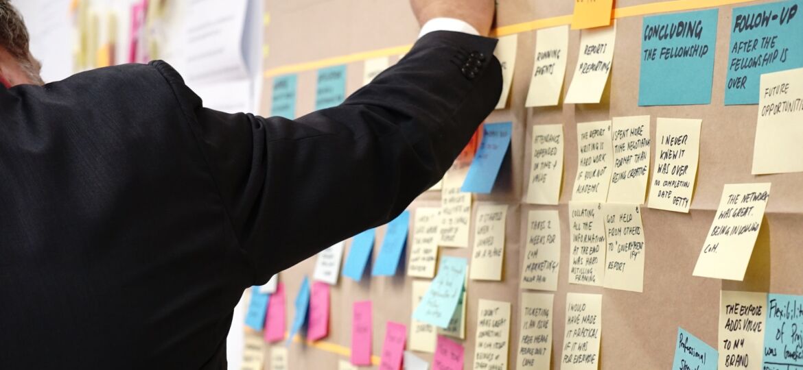 Ein Mann steht vor einem Board mit Post-its