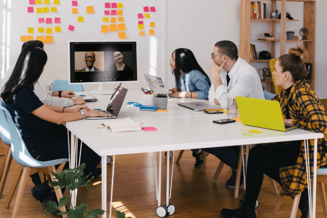 Ein Team sitzt in einem hybriden Meeting in einem Büro