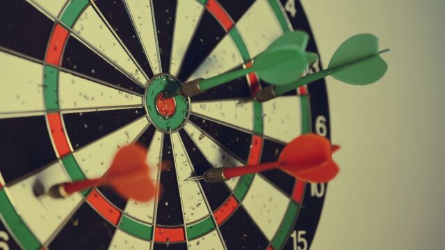 Dartscheibe mit roten und grünen Pfeilen