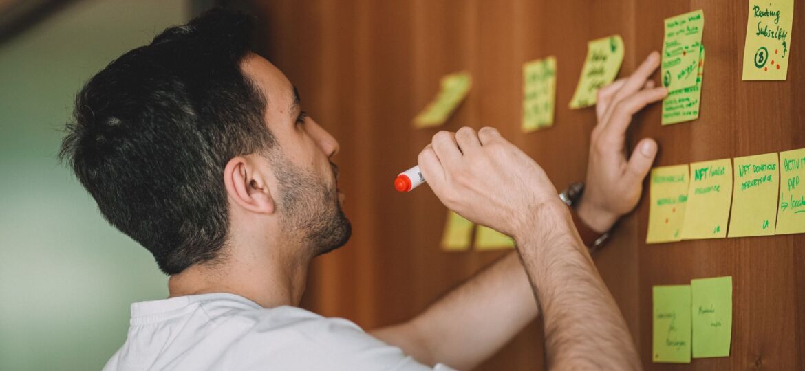 Ein Mann steht vor einer Wand mit Post-its