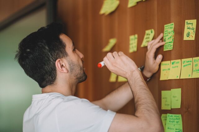 Ein Mann steht vor einer Wand mit Post-its