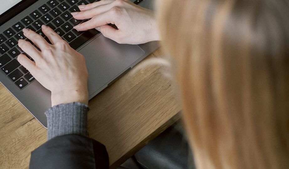 Eine Frau Tipp auf der Tastatur ihres Laptops