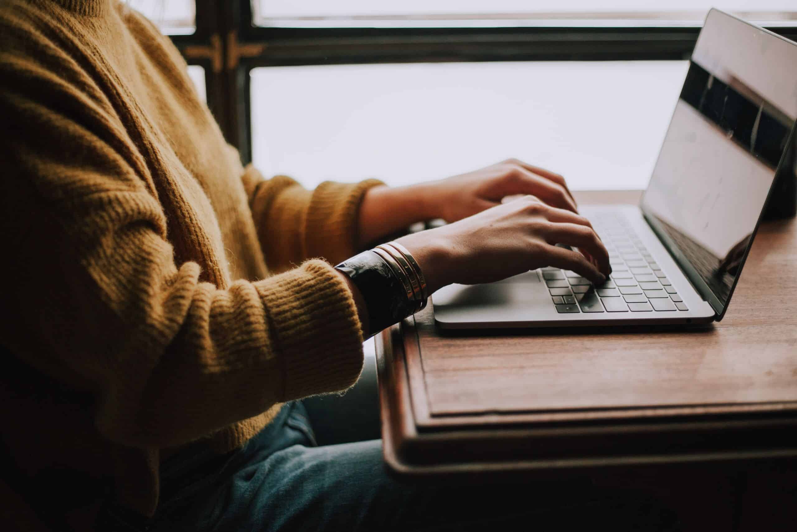 Eine Frau die auf ihrem Laptop tippt