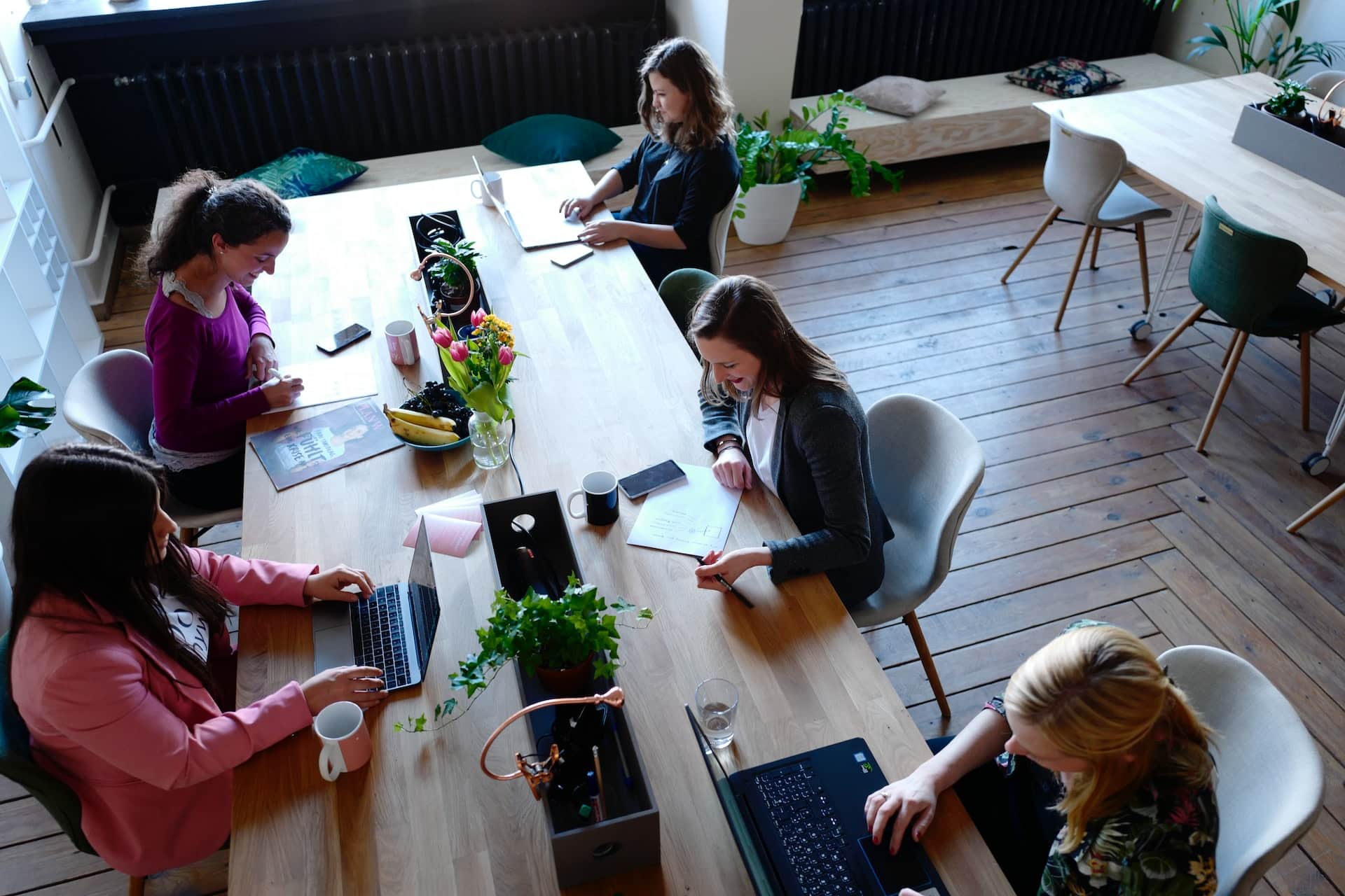 Mehrere Personen sitzen und arbeiten zusammen an einem Tisch