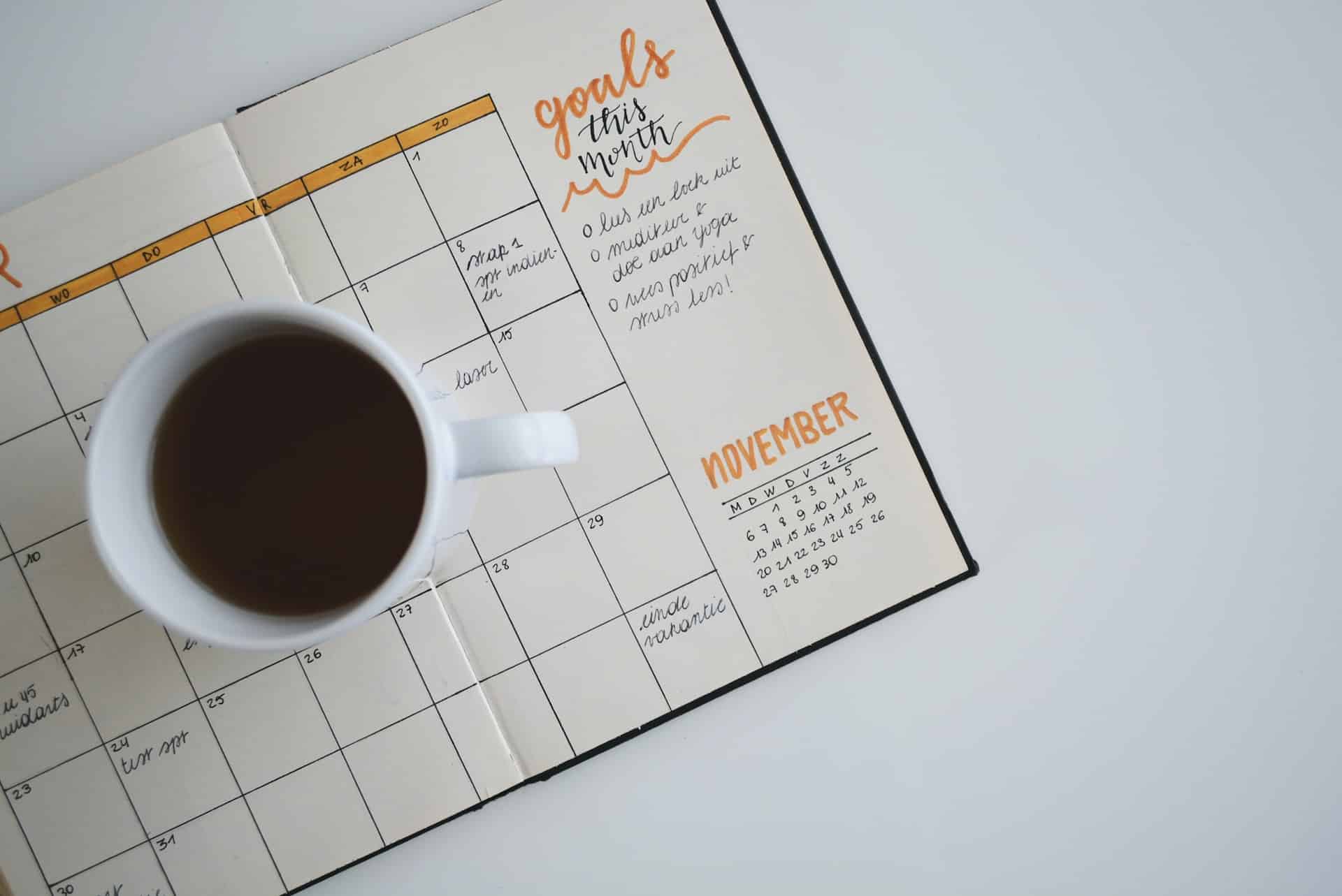 Eine Kaffetasse steht auf einem Kalender