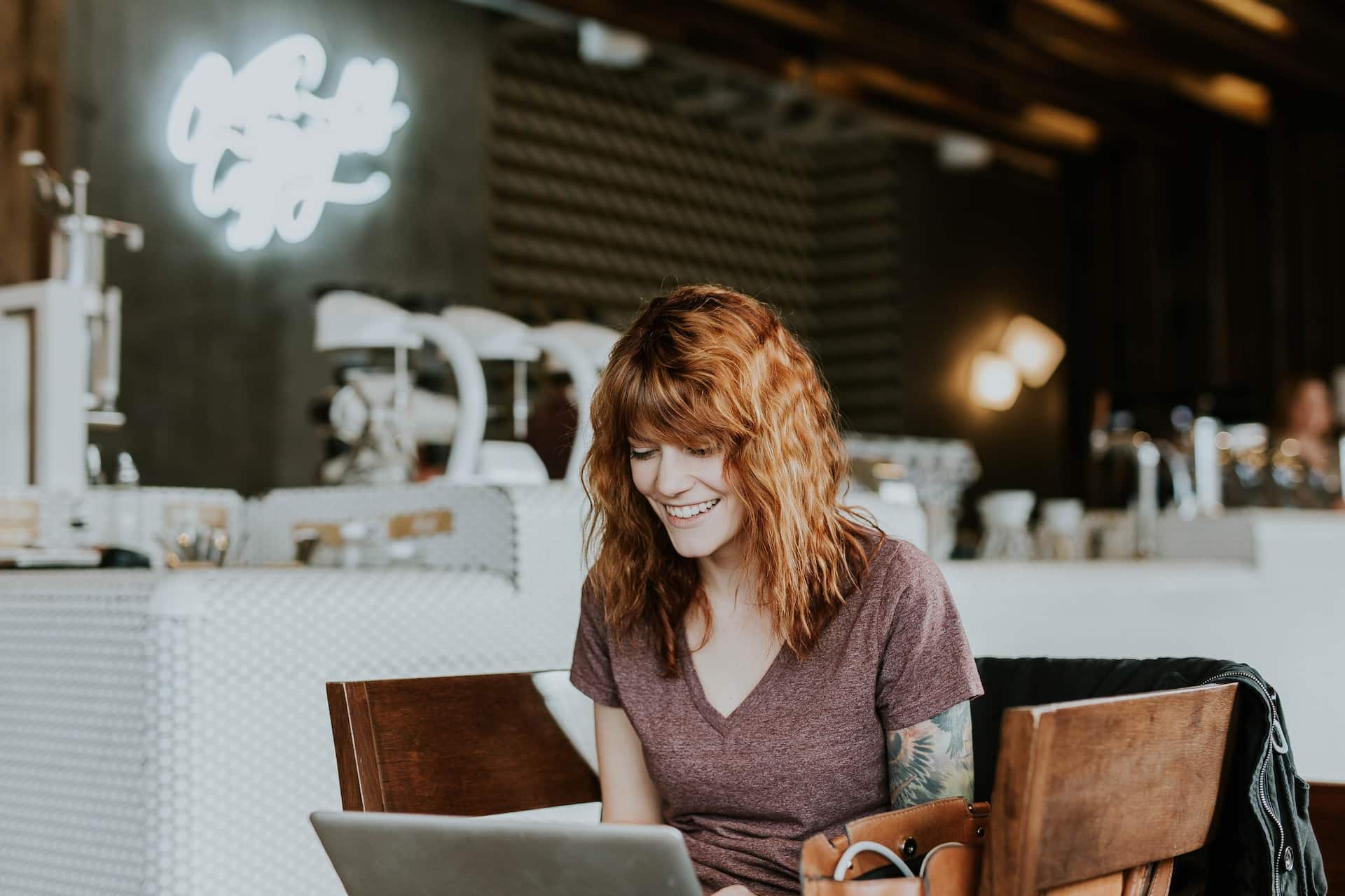 Eine Frau sitzt in einem Café und arbeitet an ihrem Laptop