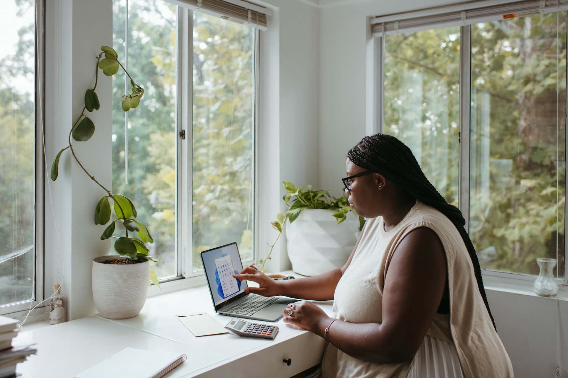 Eine Frau sitzt vor einem Laptop und arbeitet