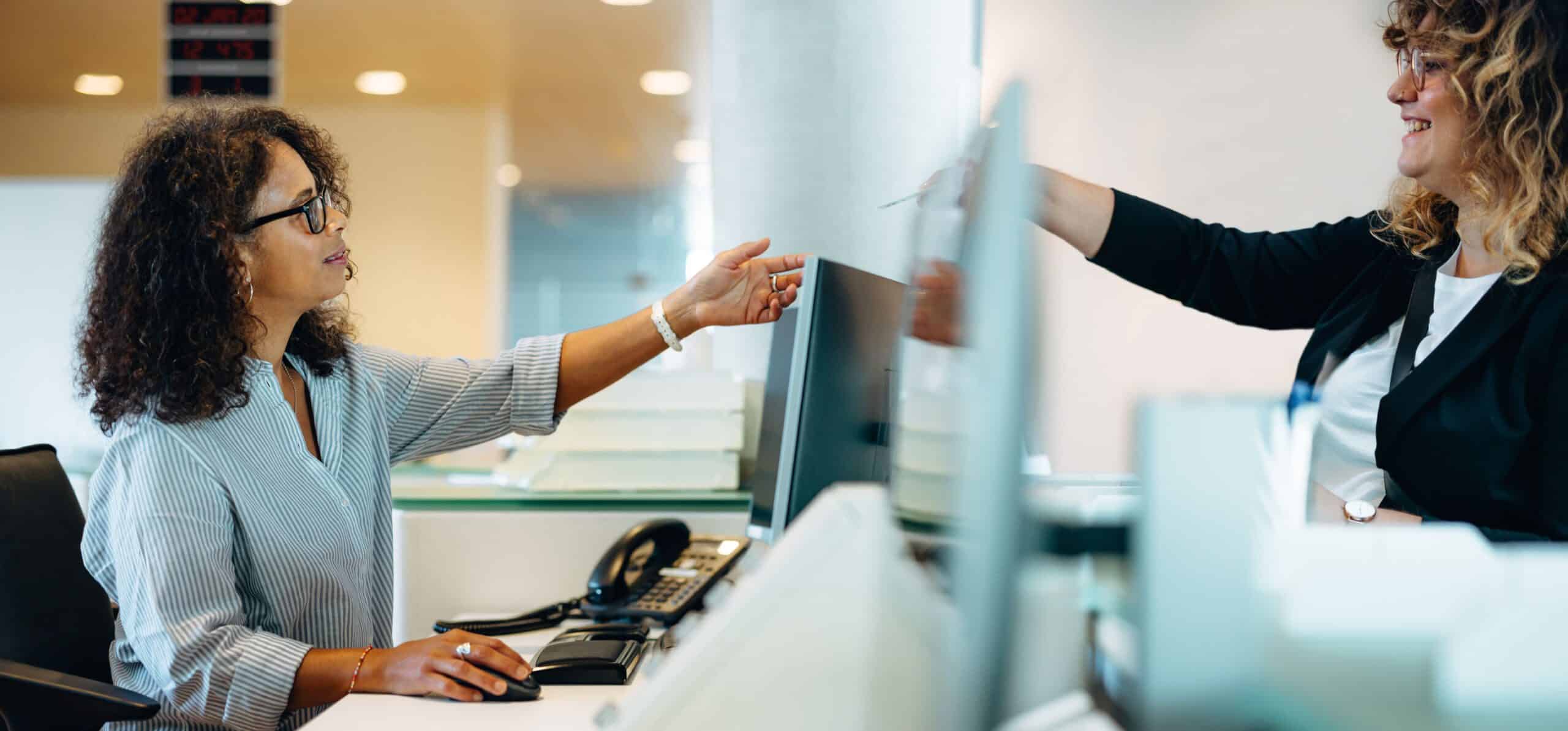 Zwei Frauen sitzen sich am Schreibtisch gegenüber