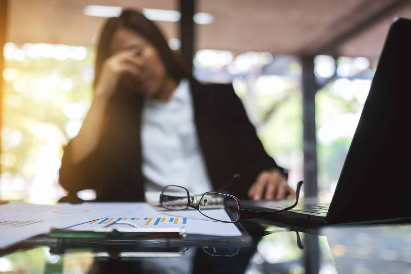 Verzweifelte Frau am Schreibtisch