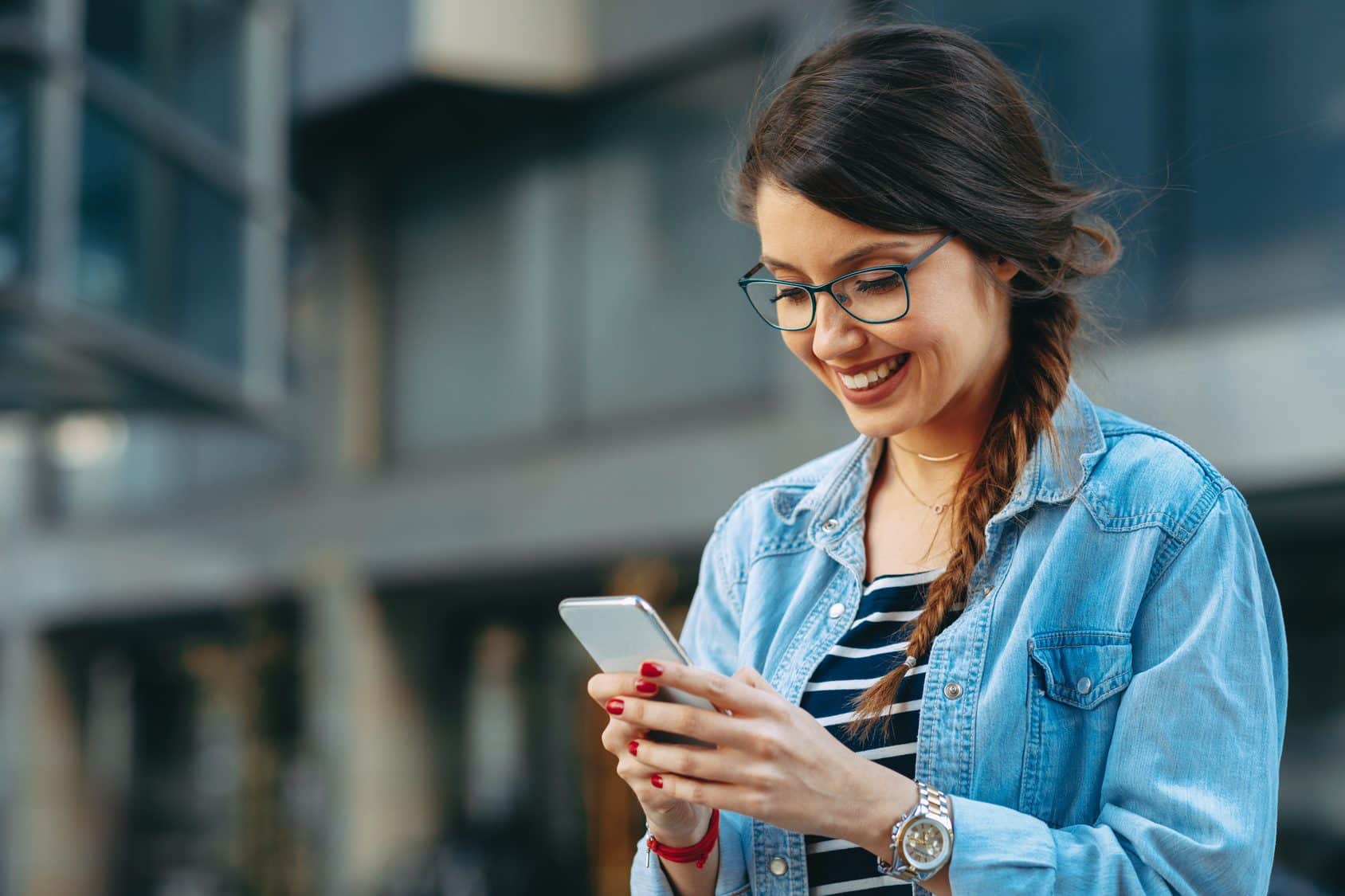 Frau schreibt mit Ihrem Smartphone eine E-Mail nach dem Feierabend