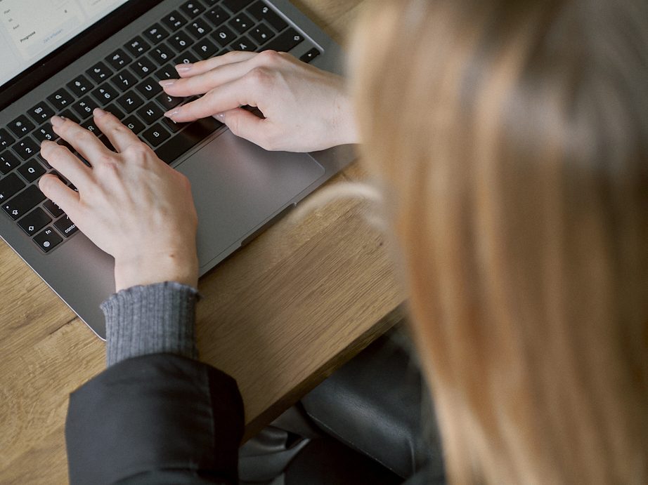 Eine Frau Tipp auf der Tastatur ihres Laptops