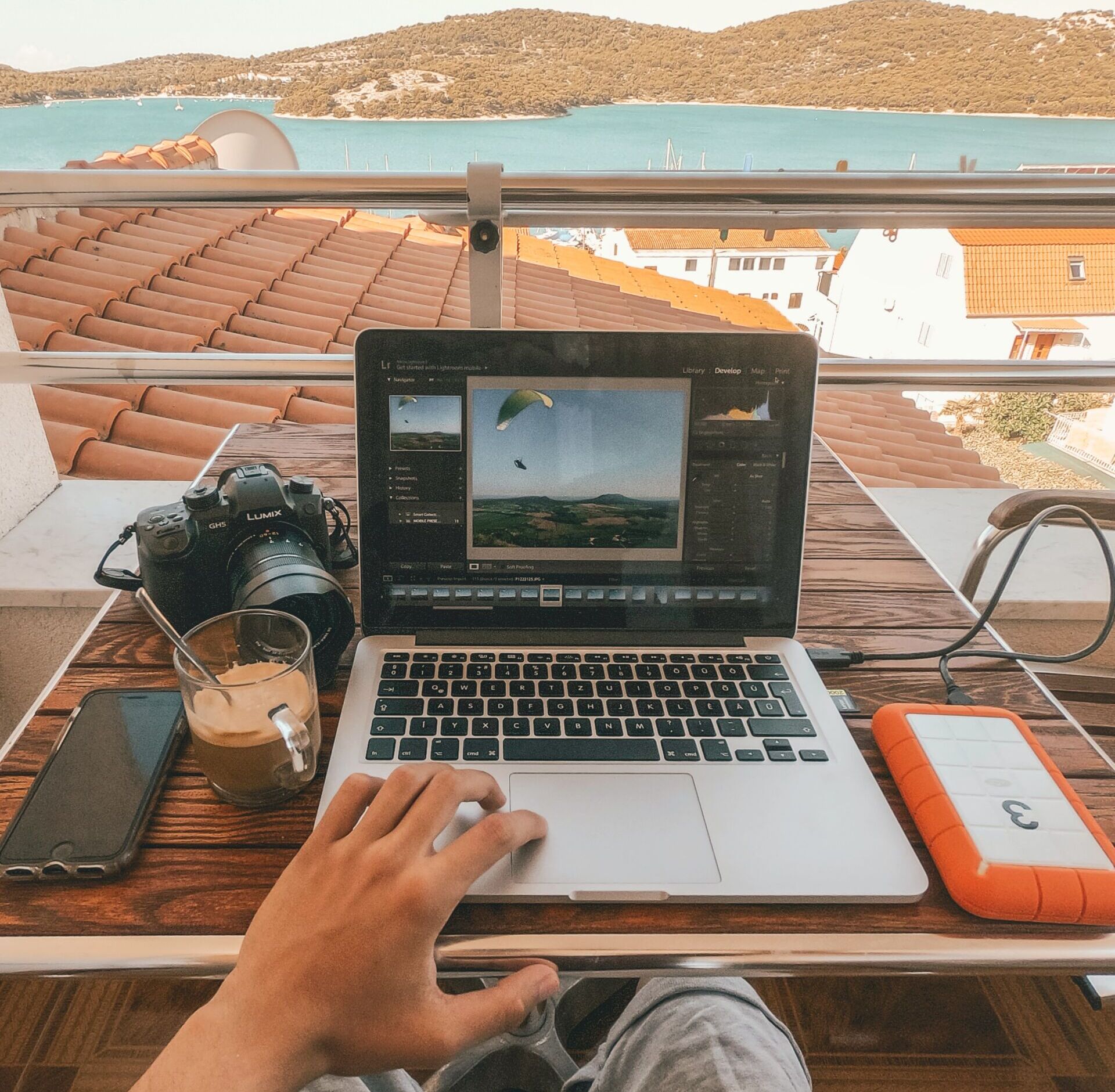 Eine Person vor dem Laptop am Meer