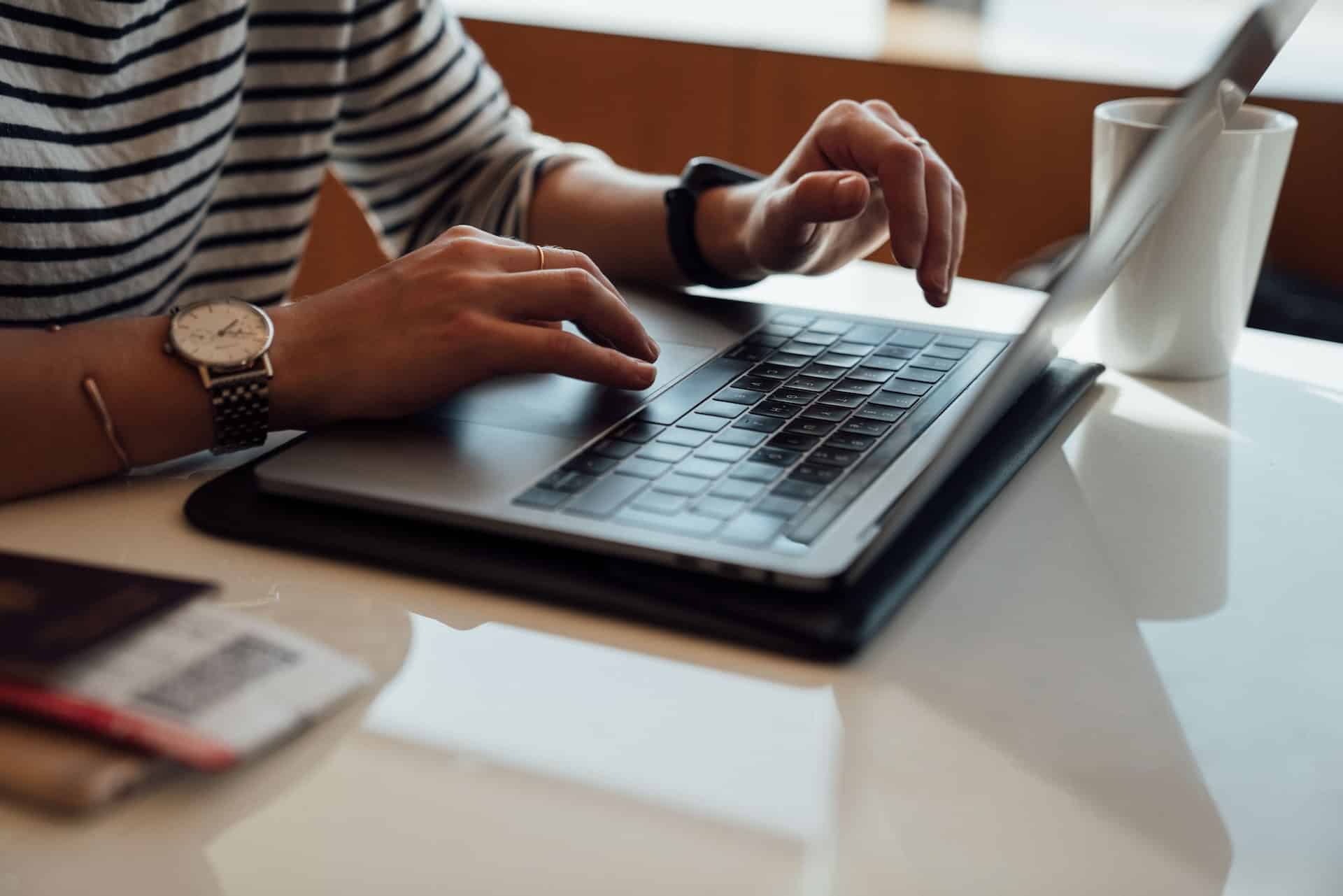 Eine Person sitz vor einem Laptop und arbeitet