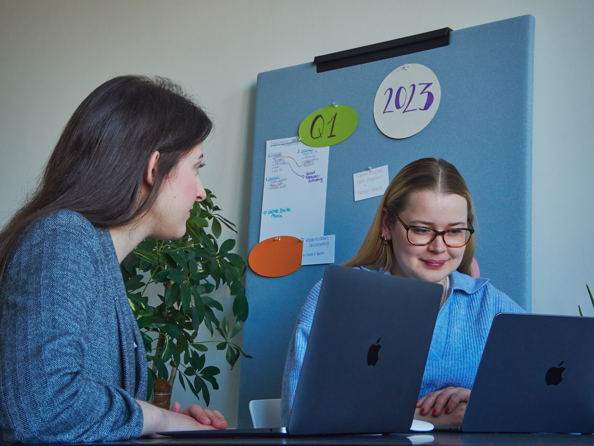 Zwei Frauen vor ihren MacBooks