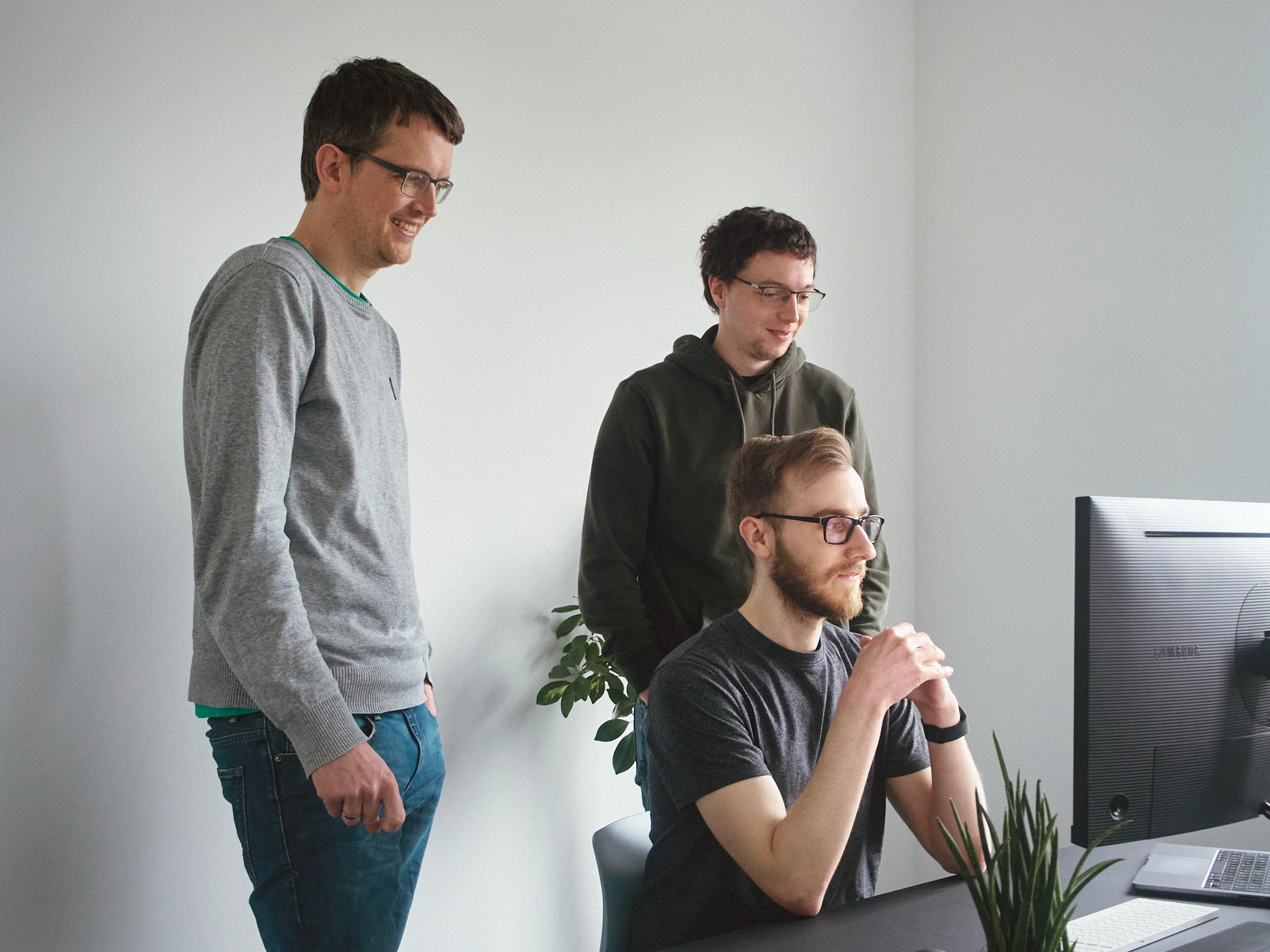 Drei Männer vor dem PC