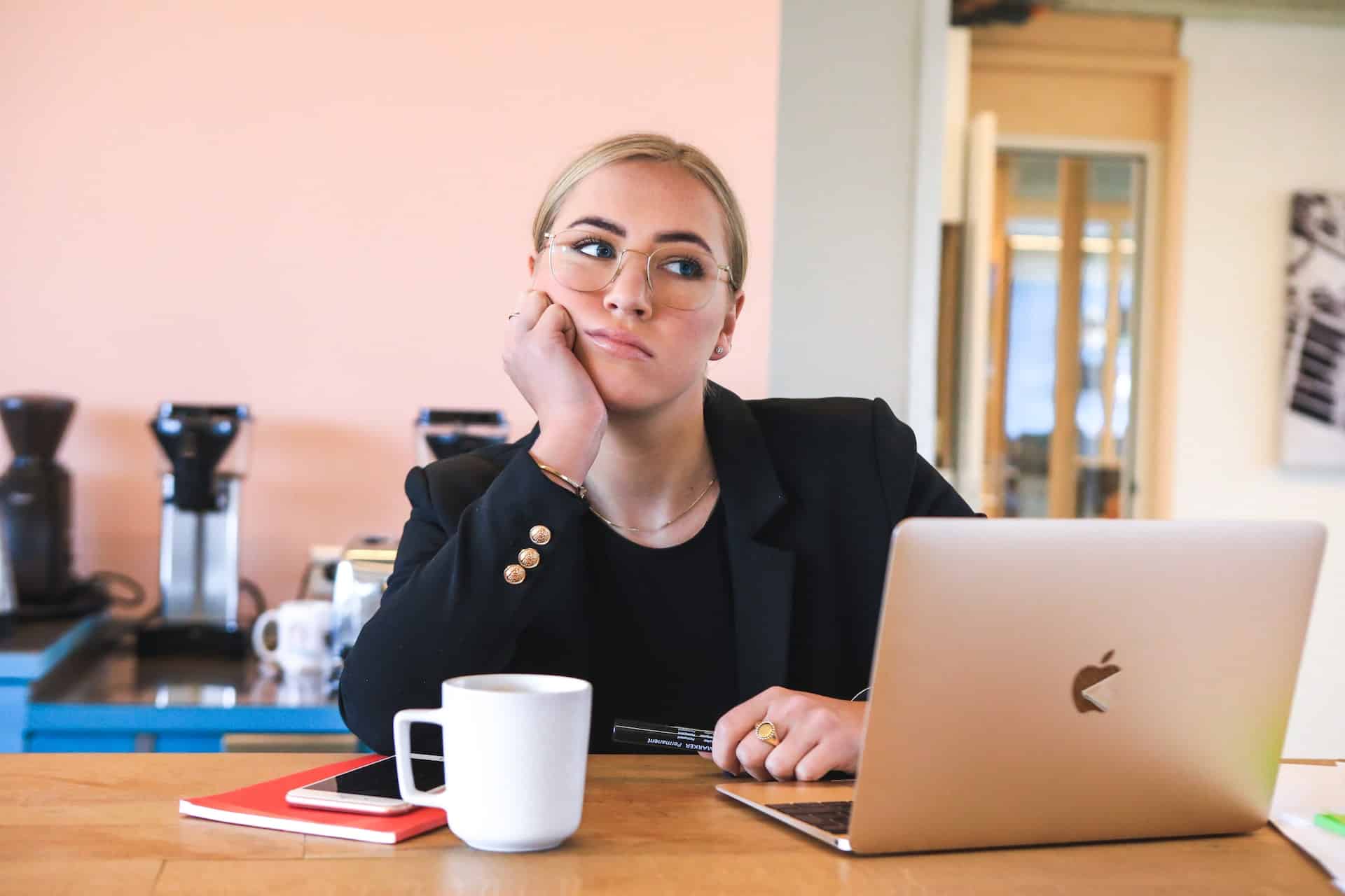 Eine Frau sitzt nachdenklich vor ihrem Laptop