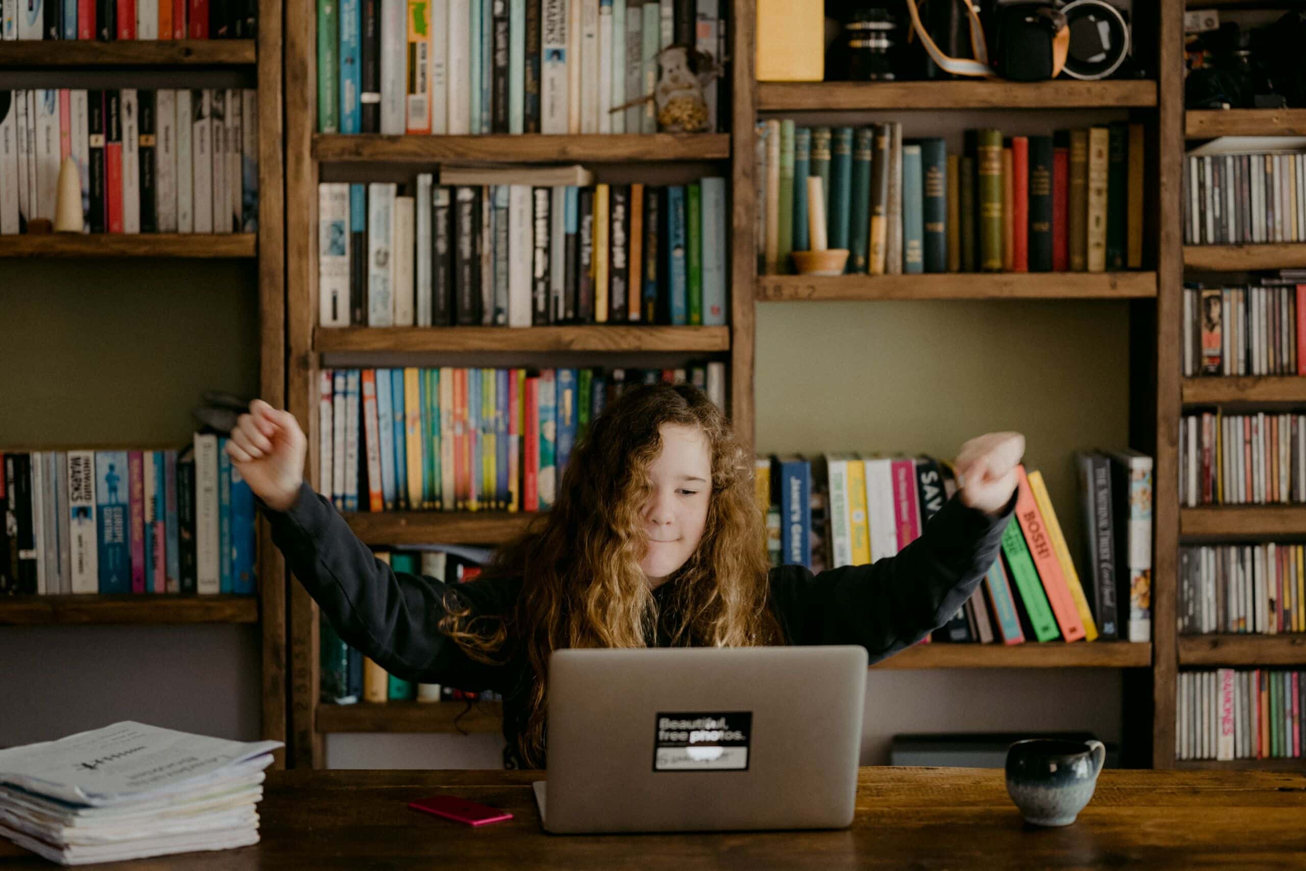 Schulkind jubelt vor Laptop