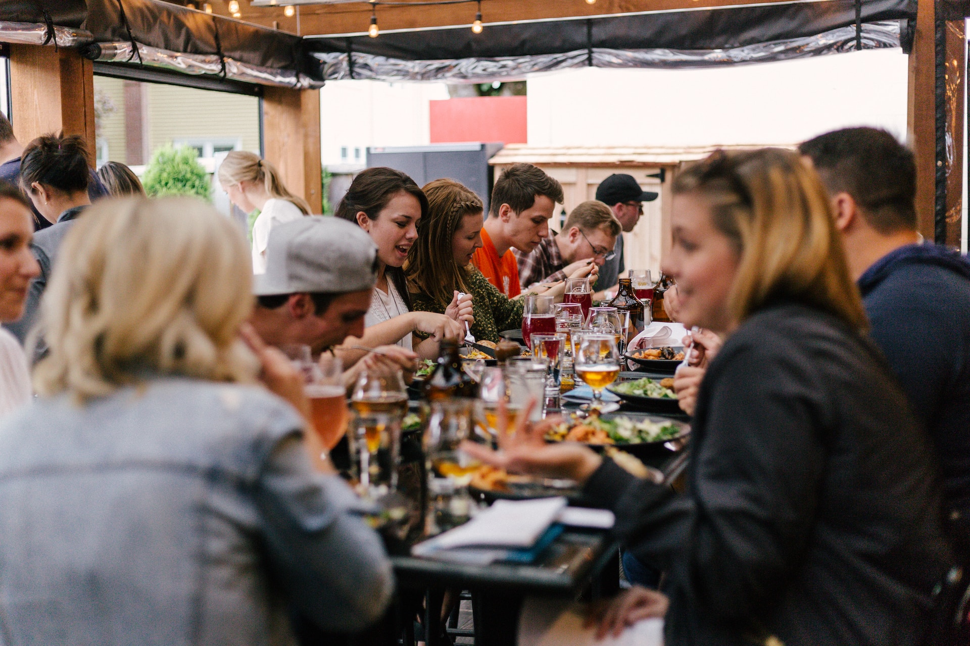 Viele Menschen sitzen an einem Tisch, unterhalten sich und essen