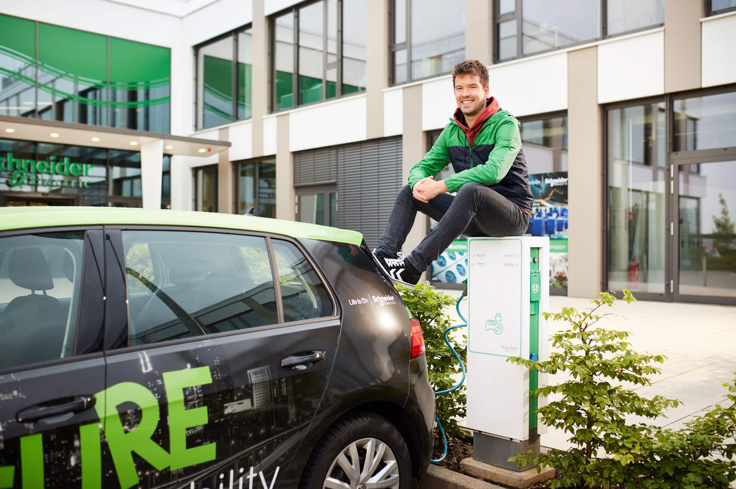 Ein Mitarbeiter von Schneider Electric bei einer Ladesäule für Elektroautos