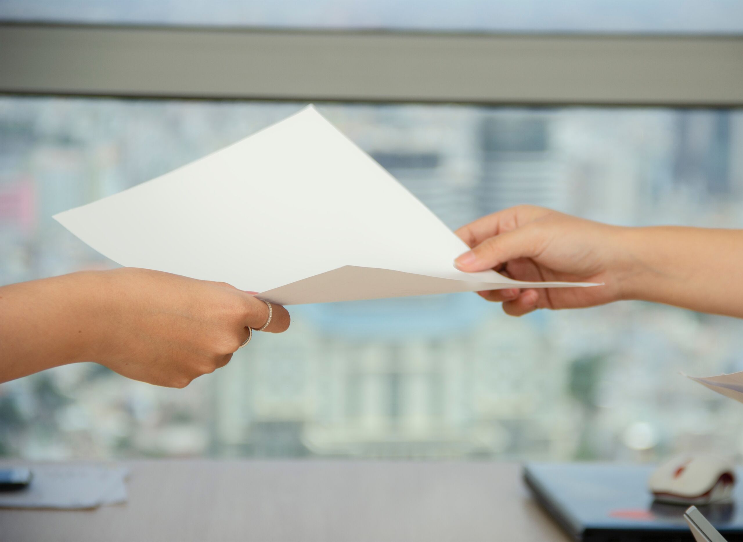 Zwei Hände reichen sich ein Blatt