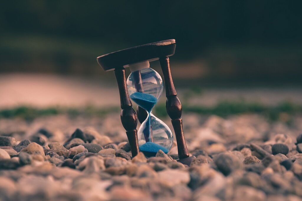 Zeiterfassung online Eine Sanduhr steht im Sand
