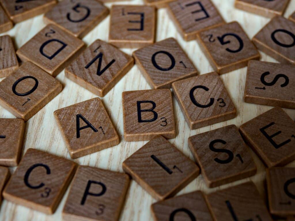 So funktioniert die ABC-Analyse: Erklärung, Berechnung & Beispiele Kleine flache Holzquadrate mit aufgedruckte Buchstaben liegen verteilt auf einem Tisch