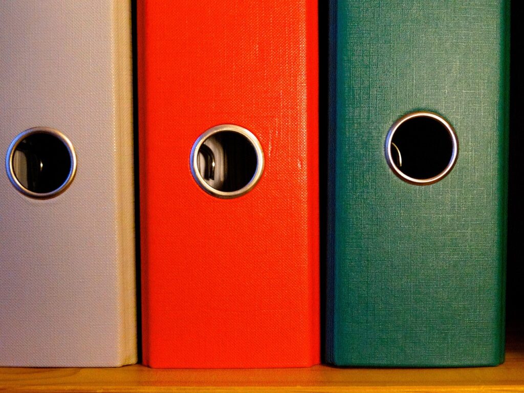 Digitale Akte: Struktur, Sicherheit und Praxis Dort snd drei Aktenordner in der Farbe, grau, rot und grün