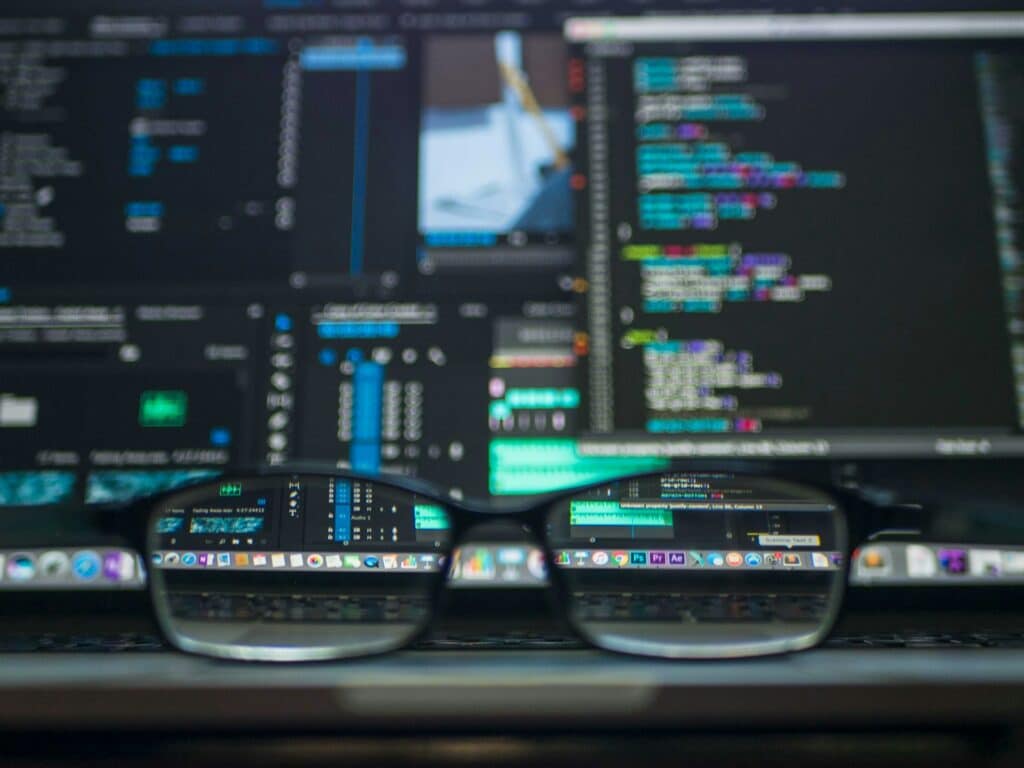 Wie Unternehmen ihre Administration durch Digitalisierung vereinfachen Eine Brille liegt vor einem Computerbildschirm. In den Brillengläser sieht man Icons auf dem Display, alles außen herum ist verschwommen
