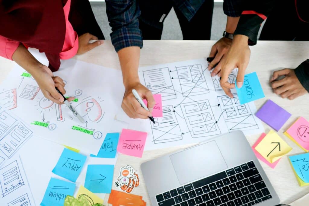 Projektmanagement Automatisierung: Prozesse vereinfachen & effizienter arbeiten Ein Schreibtisch auf dem Zettel verteil liegen und zwei PersonenDinge beschriften